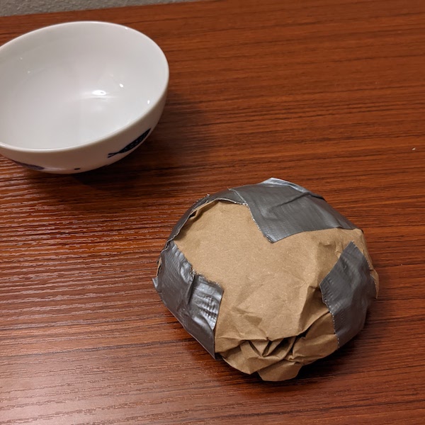 The same paper, now taped to hold its shape, removed from the bowl